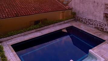 Una piscina con vistas a un paisaje urbano al atardecer.