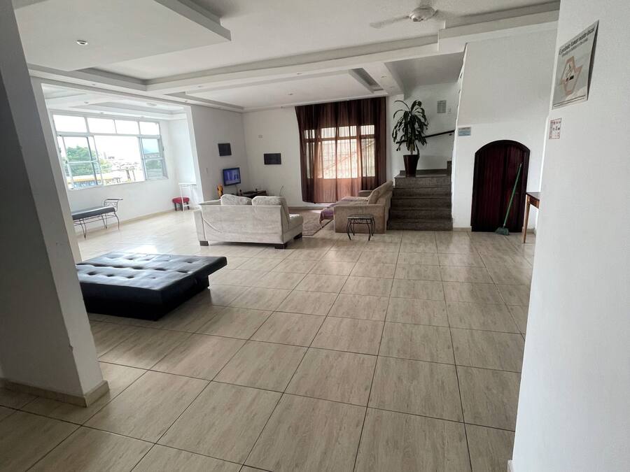 A spacious living area with a sofa set, a coffee table, and a large window providing natural light.