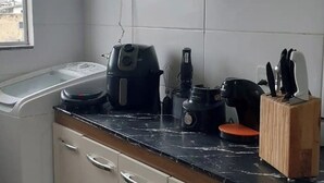 Eine Küche mit Arbeitsplatte, Kaffeemaschine, Mixer und Messerblock.