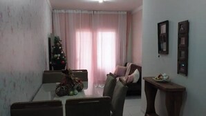 Ein Essbereich mit Tisch und Stühlen, ein Weihnachtsbaum und ein Wohnzimmer mit Sofa und kleinem Tisch.