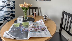 A table with newspapers, a vase with flowers, and a coffee mug. - Nice home in Jämshög with house a panoramic view (Jämshög)
