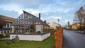 A greenhouse with a metal frame and glass panels, surrounded by a grassy area and a road. - Nice home in Jämshög with house a panoramic view (Jämshög)