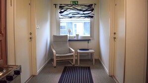 A narrow hallway with a chair and a small table near a window, a radiator below, and a door with the number 20 on it. - Nice home in Jämshög with house a panoramic view (Jämshög)