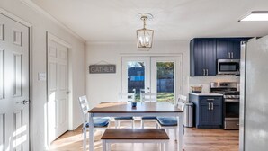 Et moderne køkken med mørke skabe, et rustfrit stål køleskab og en mikroovn.