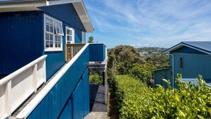 A blue building with a white railing and a wooden deck.