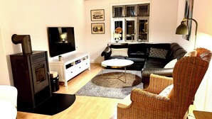 A living room with a fireplace, a sofa, a coffee table, and a wicker chair.