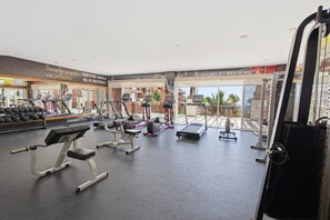 A gym with treadmills, weight machines, and a rowing machine.