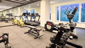 Uma academia com esteiras, máquinas de musculação e equipamentos de exercícios.