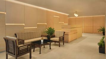 A modern reception area with a sofa, chairs, a coffee table, and a reception desk.