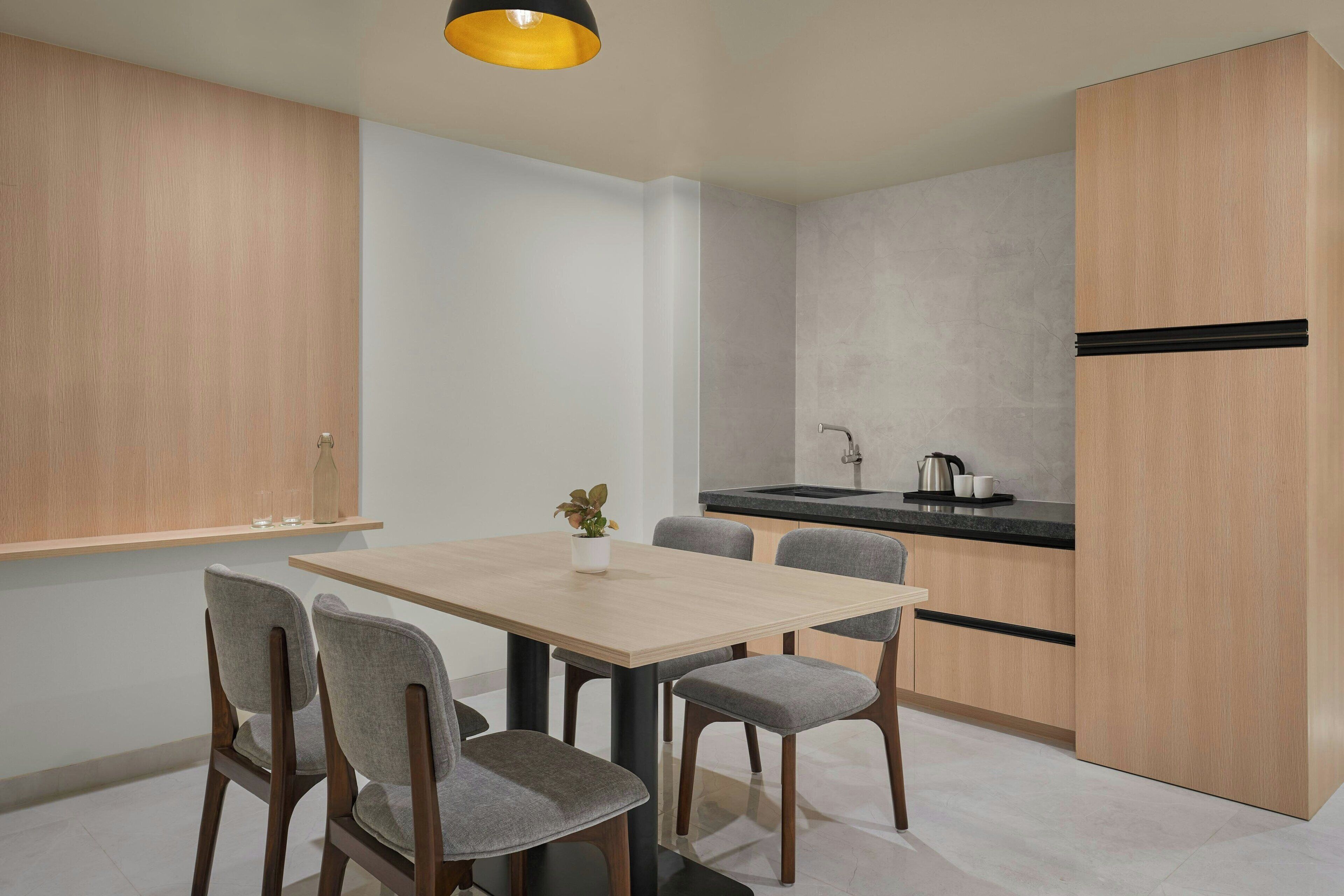 A modern kitchen with a wooden cabinet, a black countertop, and a sink.