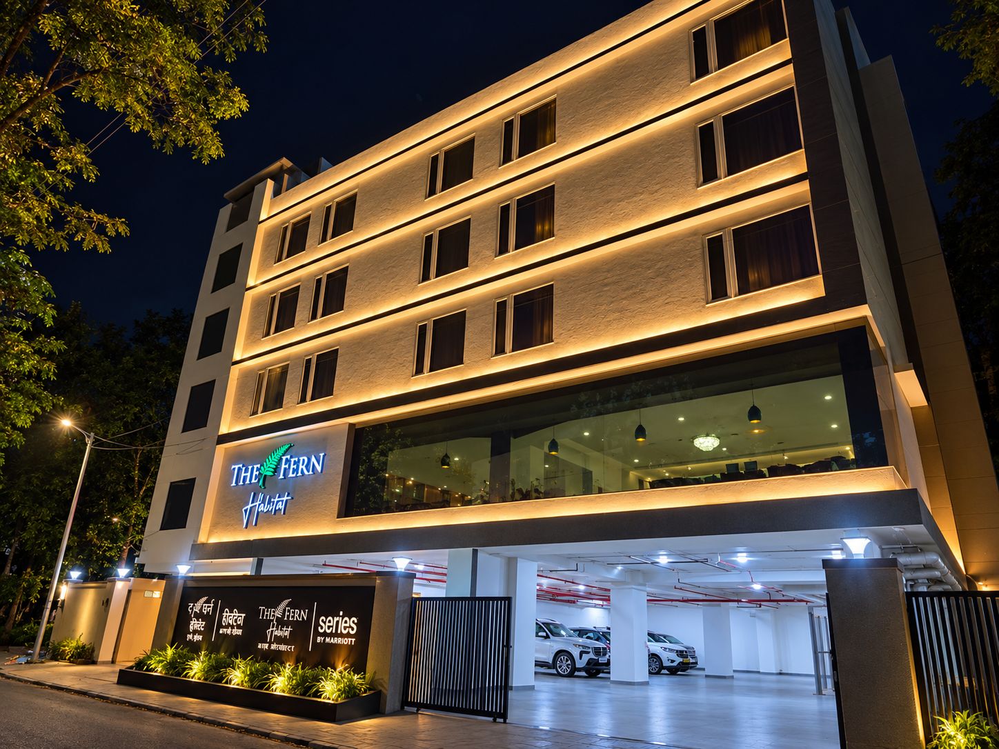 A hotel with multiple floors, a parking garage, and a sign indicating it's part of the 'The Fern' hotel series by Marriott.