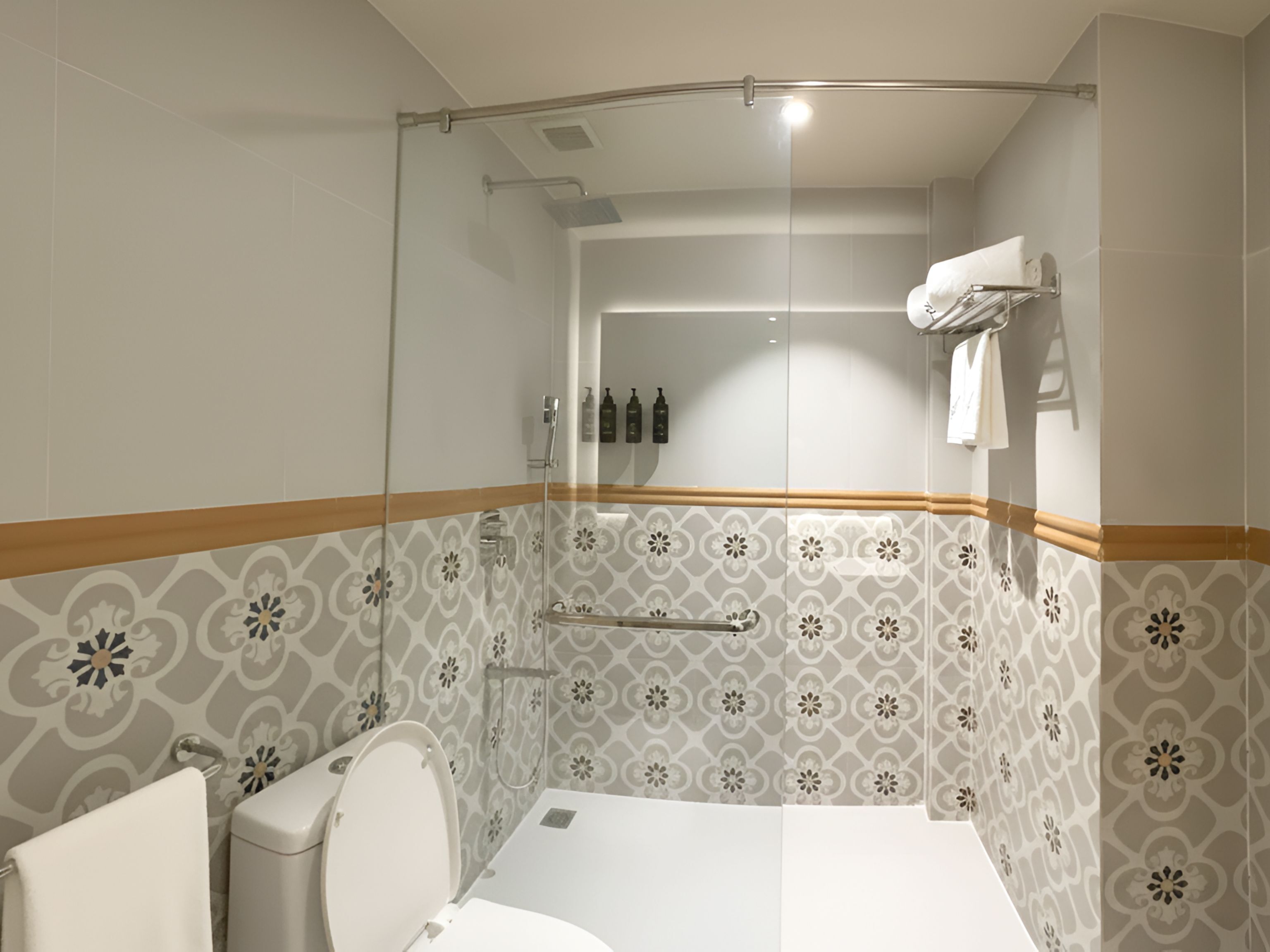 Een moderne badkamer met douche, toilet en wastafel.