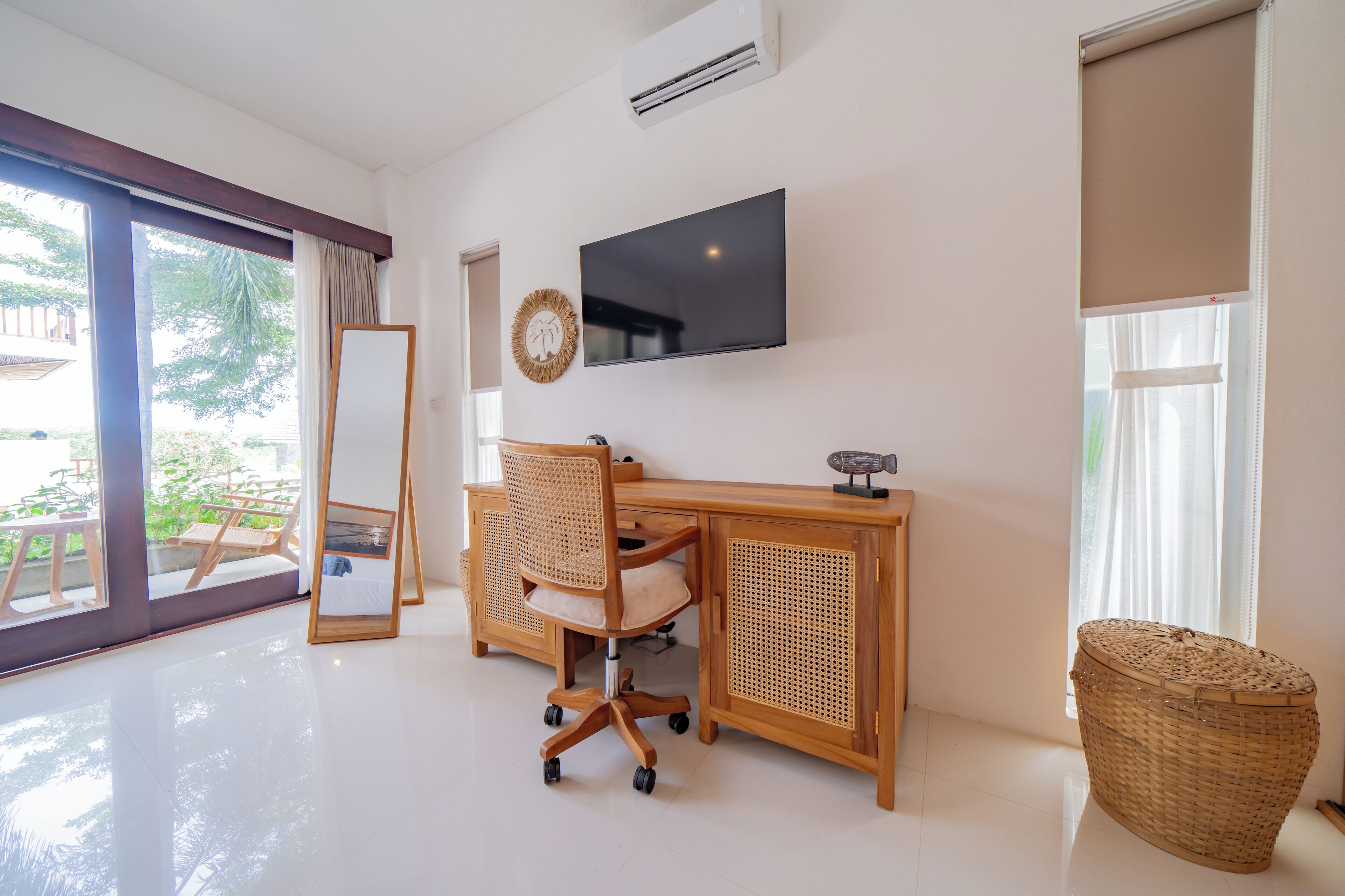 A modern office space with a wooden desk, ergonomic chair, and a large flat-screen TV.