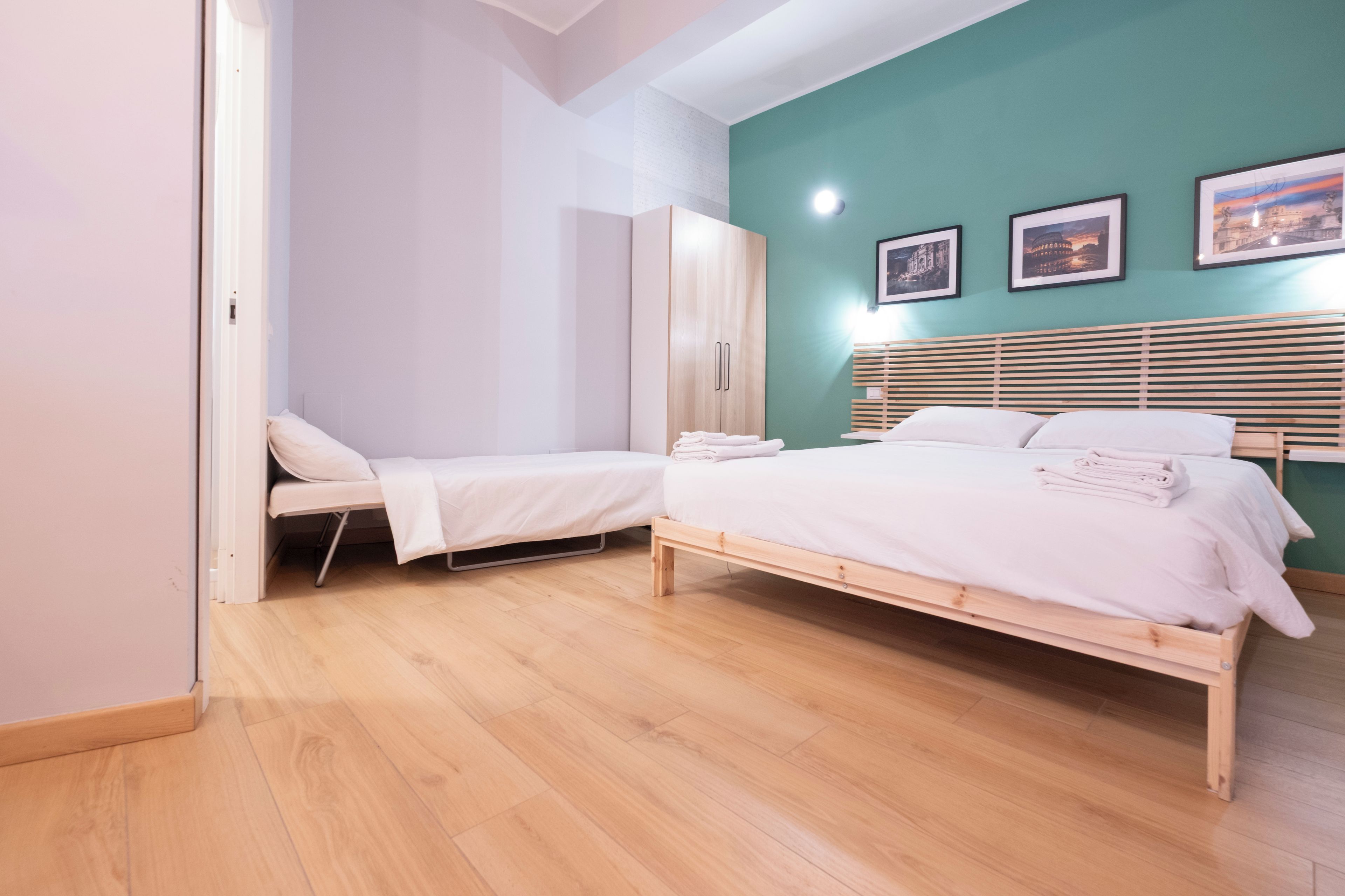 Quarto com cama, guarda-roupa e um banco.