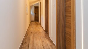 A hallway with wooden flooring and doors. - Apartman Irena by Interhome (Medici)