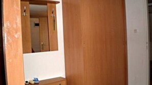 A room with a wooden wardrobe, a mirror, and a small dresser. - U SEMUSHKY Apartment 3 by Interhome (Pernink)