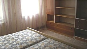 A room with a bed, a wooden wardrobe, and a window with curtains. - U SEMUSHKY Apartment 3 by Interhome (Pernink)