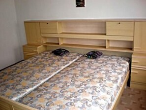 A bedroom with a bed, two pillows, and a headboard with built-in shelves. - U Semushky Apartment 3 by Interhome (Pernink)