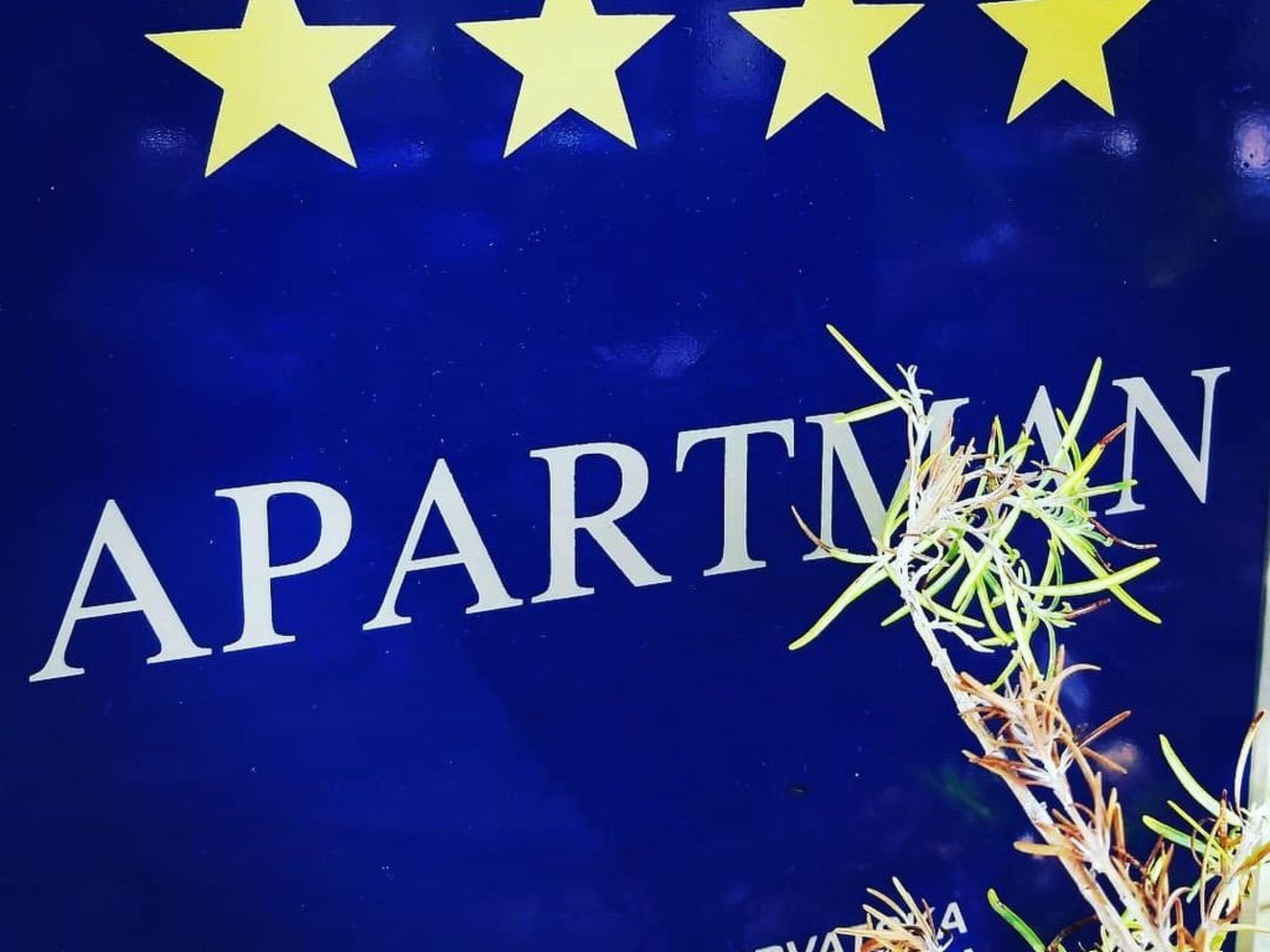 A sign with the word "APARTMENT" and three stars above it.
