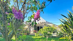 A house with a garden, a tree with purple flowers, and a clear blue sky. - Étel – 3-room house – 110 m² – WiFi - 3* (ETEL)