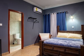 A bedroom with a wooden bed, a hanging chair, a shower, and a toilet. - Clean beds, Sound Sleep (Accra)