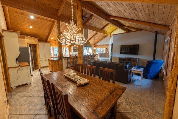 A spacious wooden interior with a dining area, kitchen, and living space.