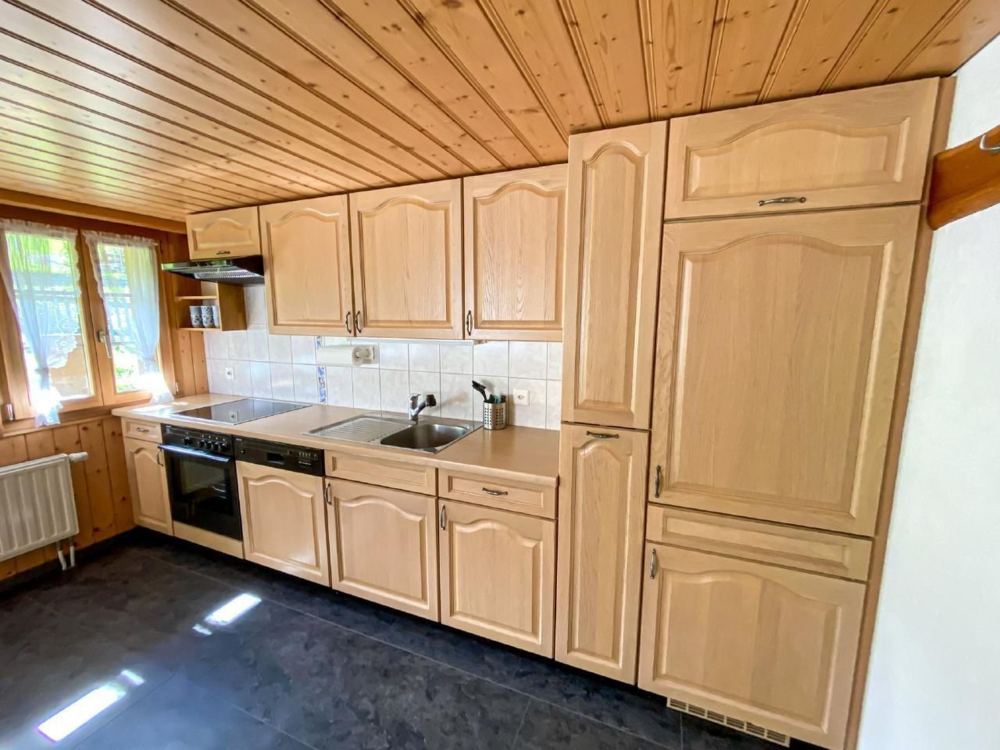A kitchen with wooden cabinets, a dishwasher, and a sink.