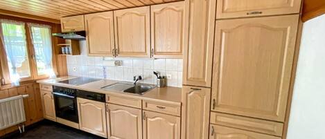 A kitchen with wooden cabinets, a dishwasher, and a sink.