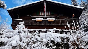 A wooden chalet with a steep roof, surrounded by snow-covered trees. - Chalet Tannegüetli by Interhome (Grindelwald)