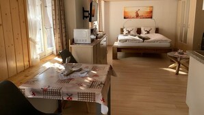 A cozy room with a bed, a desk, a chair, and a table with a tablecloth. - Chalet Fluehbluemli / Eigerview by Interhome (Grindelwald)