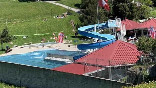 A mountain resort with a swimming pool, a flag, and buildings in the foreground. - Chalet Fluehbluemli / Eigerview by Interhome (Grindelwald)