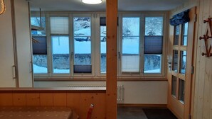 A room with a bed, a radiator, and a view of a snowy landscape through large windows. - Eschengasse 21 by Interhome (Grindelwald)