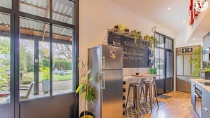 Eine moderne Küche mit integriertem Kühlschrank, Barhocker und einer Tafel mit Speisekarte.