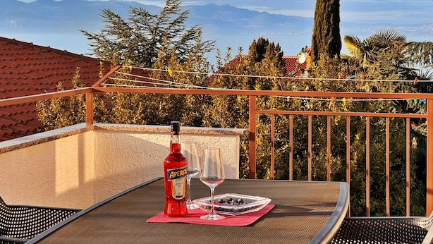A balcony with a table, a bottle of Aperol, and two wine glasses. - Apartment Katarina by Interhome (Krk/Milohnići)