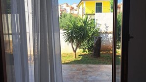 Una habitación con puerta de vidrio corredera que da a un patio.