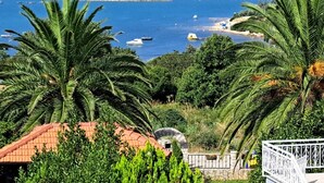 Une vue sur la côte, avec une mer bleue et limpide, des bateaux et une végétation luxuriante.