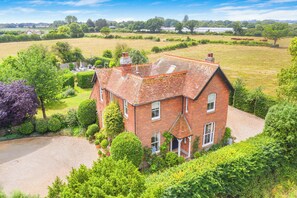 A large brick house with a spacious yard and a well-maintained garden. - House Annexe Sleeps 18 Heated Pool (Chichester)