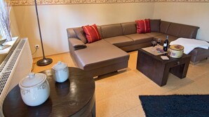 A living room with a brown sofa, a dark coffee table, and a floor lamp. - Vacation home Marcel by Interhome (Hage)