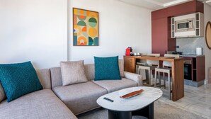 A modern living room with a sofa, a coffee table, and a kitchen area with a microwave. - Charmante Wohnung 42 by Interhome (Casablanca)