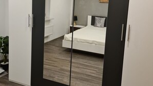 Ein Schlafzimmer mit großem Kleiderschrank, einem Bett und einem Nachttisch.