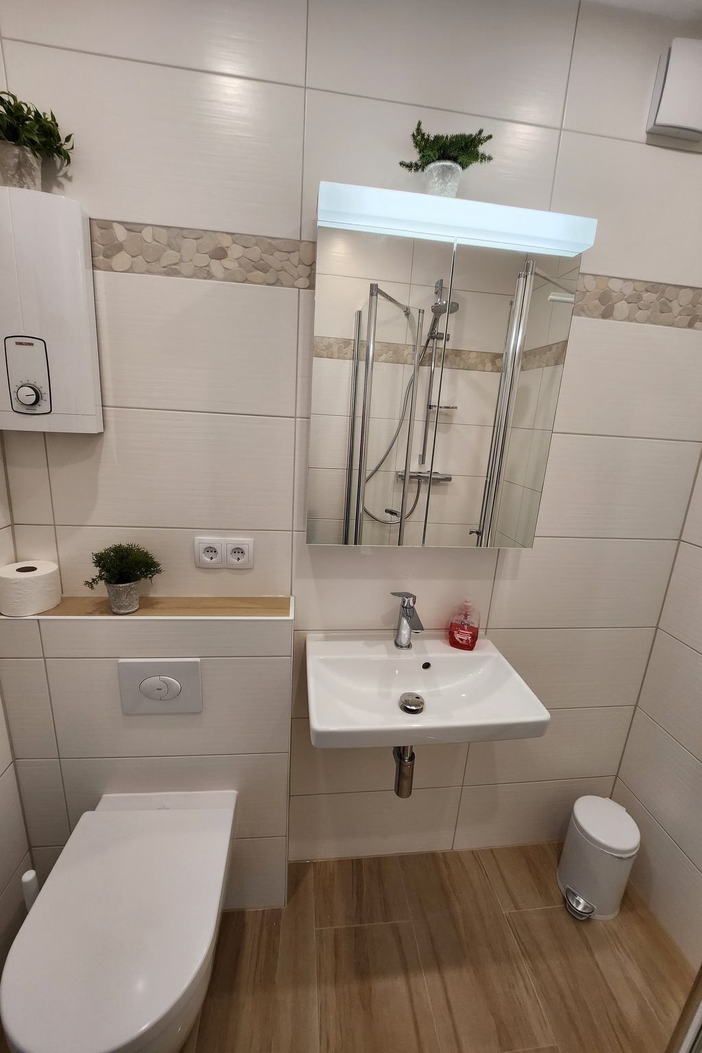 Ein modernes Badezimmer mit Toilette, Waschbecken und Dusche.