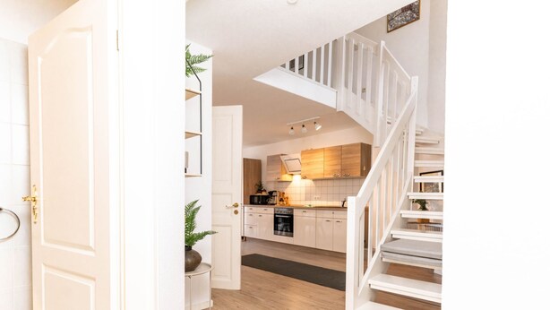 A modern kitchen with wooden cabinets, a built-in oven, and a microwave. - Himmelskoje mit Große Dachterrasse & Hafenblick by Interhome (Altstadt)