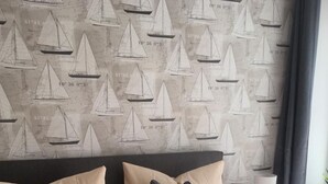 A bedroom with a bed, pillows, a nightstand, and a lamp. - Admiralskoje by Interhome (Altstadt)