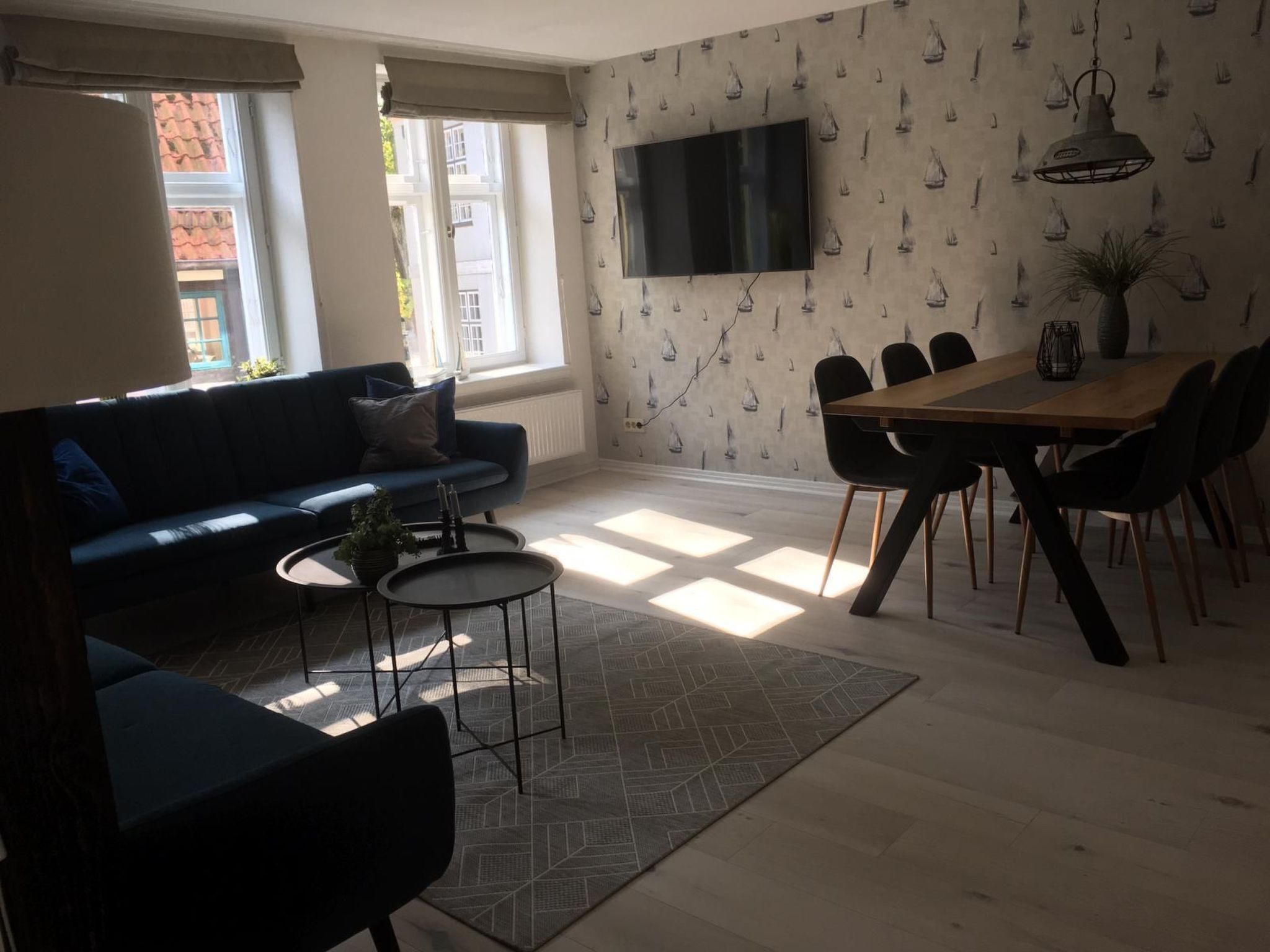 Un salon moderne avec un canapé, une table basse et un coin repas avec des chaises.