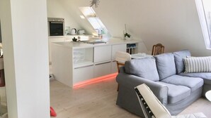Um apartamento moderno no estilo loft, com cozinha, sala de jantar e sala de estar.