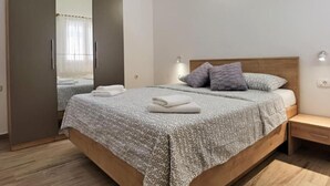 Una camera da letto con un letto, un comodino, un armadio e uno specchio.