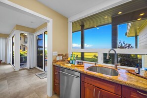 A modern kitchen with a large window, a stainless steel sink, and a dish drying mat. - Kapalua Bay | Ocean View 2 BR, Sleeps 8 | Car Incl. w/ 6+ Nights | KBV ML-3488 by KBM (Lahaina)