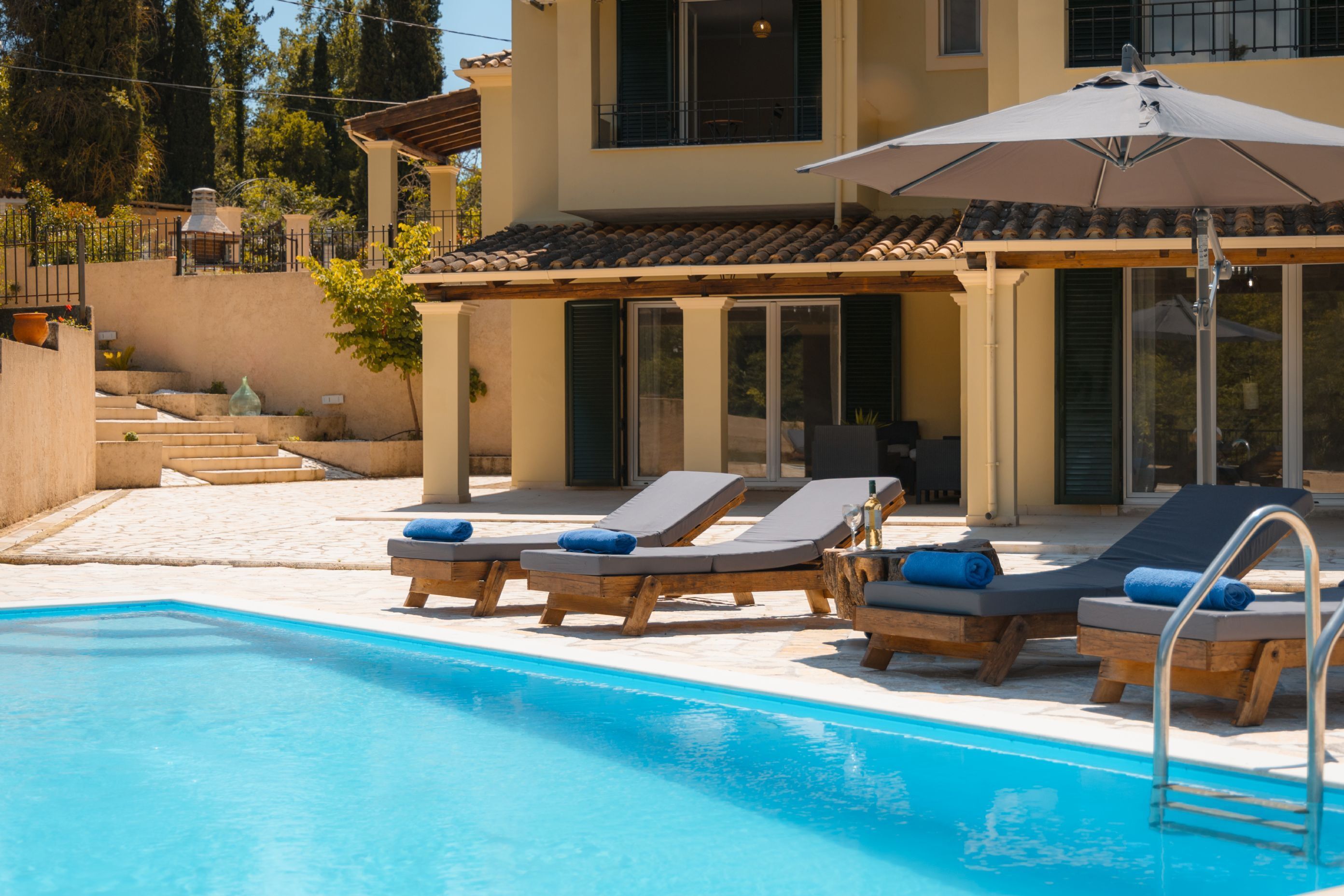 Ein Poolbereich mit Liegestühlen und Sonnenschirm.