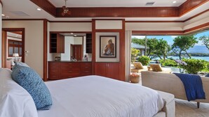 Ein Schlafzimmer mit einem großen Bett, einer Sitzecke mit Blick und einem Badezimmer mit Spiegel und Schränken.