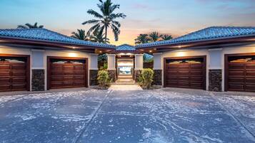 A building with multiple garage doors, a stone facade, and a paved driveway.